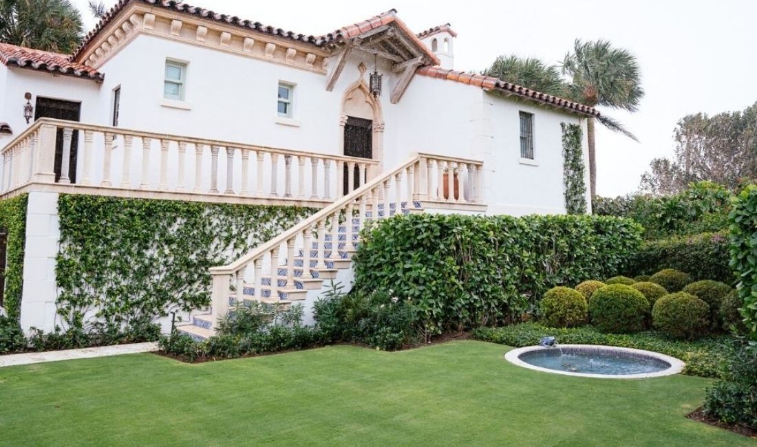 A Palm Beach property with green grass and professionally landscaped grounds maintained by Coastal Gardens.